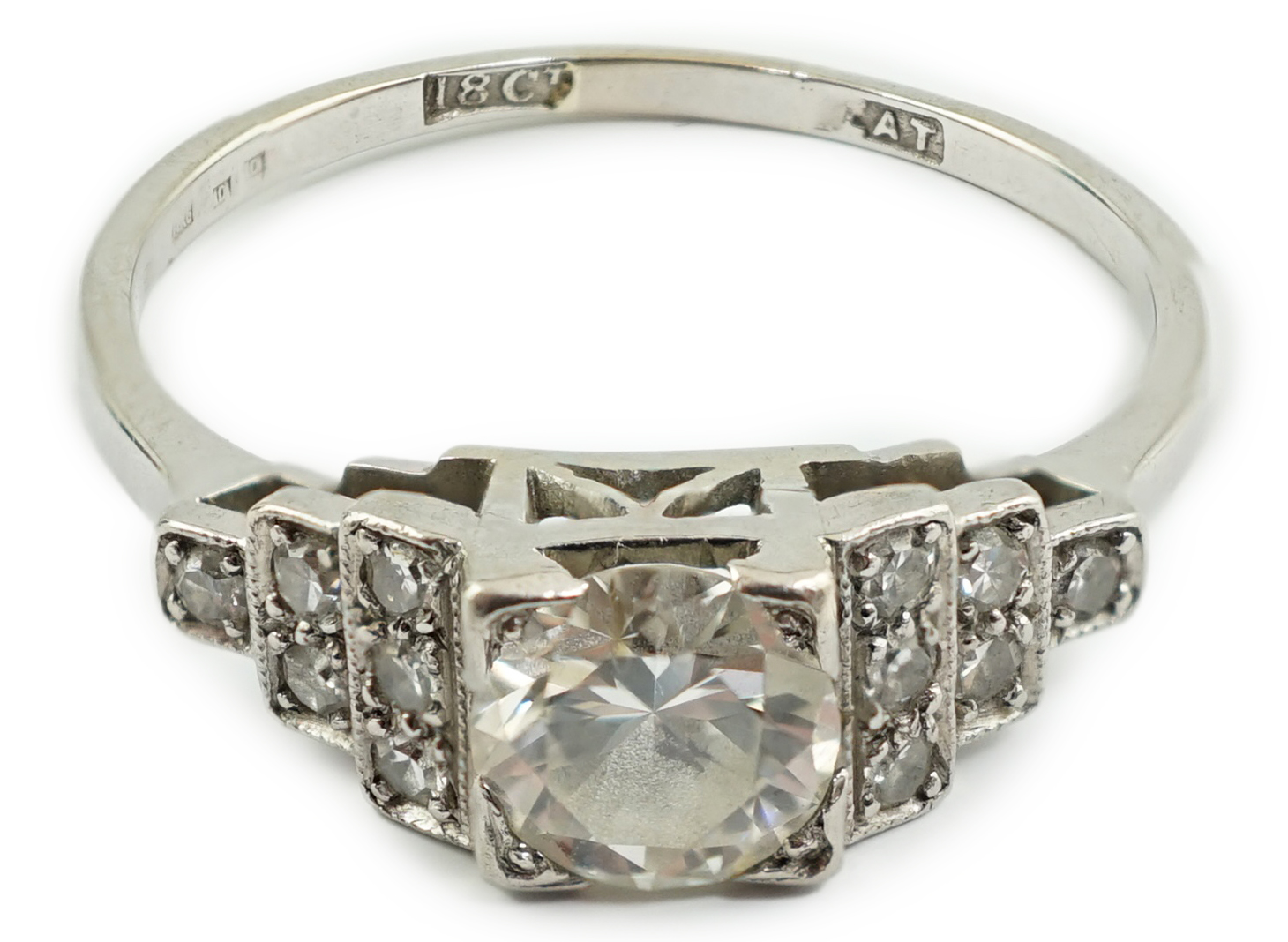 An Art Deco 18ct white gold, platinum and single stone diamond ring, with twelve stone diamond chip set stepped shoulders